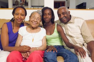 Couple sitting with their teenage daughter and mother in-law on a couch