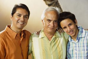 Three generations of men posing for the camera