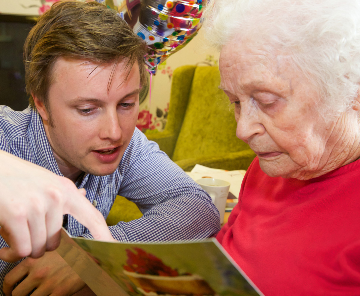 Grandson helps his Grandmother read her birthday card