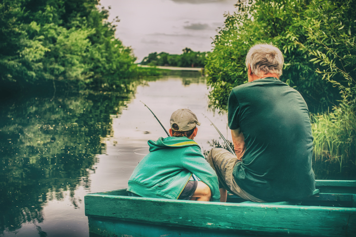 grandfather and boy fishing together. HDR. boy and an old man si