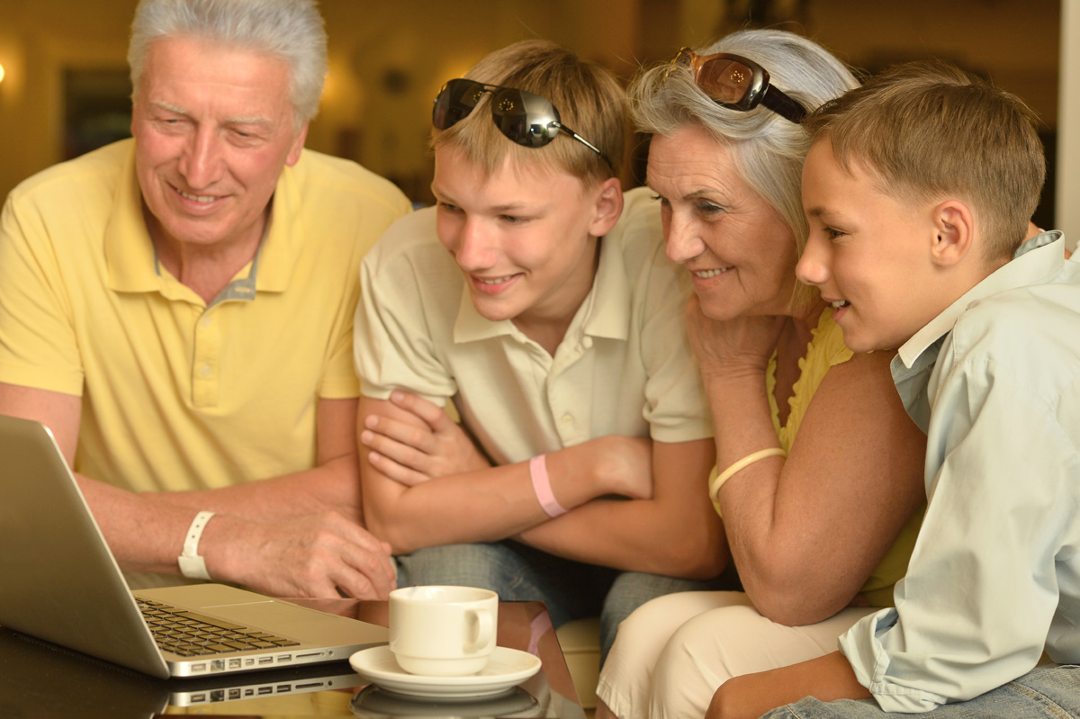 Portrait of a happy boys with grandparents  and laptop